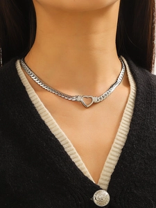 Fashionable silver heart pendant on a chunky snake chain worn by a female model