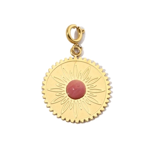 Dettaglio di un ciondolo a sole dorato con pietra naturale rosa e chiusura in acciaio inox
