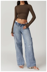 Detail view of a slim-fit brown cropped long sleeve shirt with blue distressed jeans