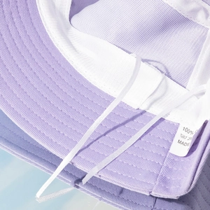 Detail view of purple bucket hat interior showing sewing lines and 100% cotton wash label