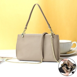 Detail view of khaki pebbled leather bag with golden chain and inner zipper compartment