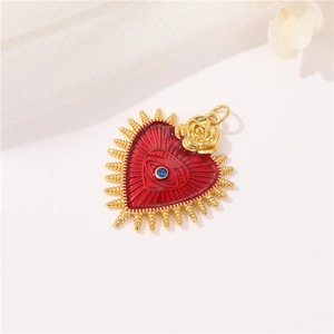 Detail view of heart-shaped gold pendant with red enamel, blue gemstone and a golden rose