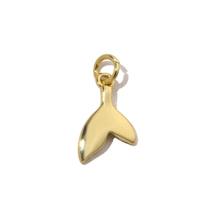 Macro detail of a polished golden fish tail pendant with a smooth metallic finish