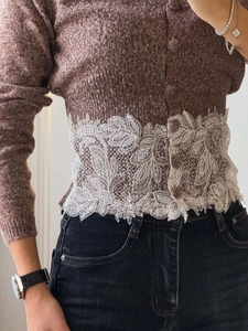 Detailansicht eines braunen Strick-Cardigans mit breitem weißem 3D-Blumenspitzenbesatz
