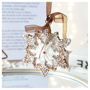 Close-up of snowflake gingerbread man resin ornament with warm glowing bokeh lights