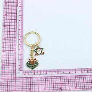 Detail of Christmas keychain with Santa star and reindeer heart pendant on a scale mat