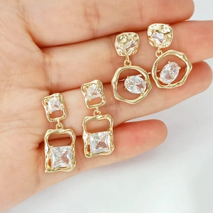 Handheld view of 14K gold plated geometric earrings with sparkling zircon inlay