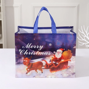 Christmas non-woven gift bag with blue handles and Santa Claus reindeer star print
