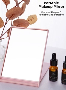 Adjustable light pink folding makeup mirror on a vanity with multi-angle support