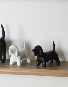 Detail of minimalist ceramic dog statues with matte black and white finishes