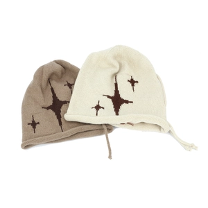 Detail of khaki and beige beanies with star pattern and soft knit texture finish