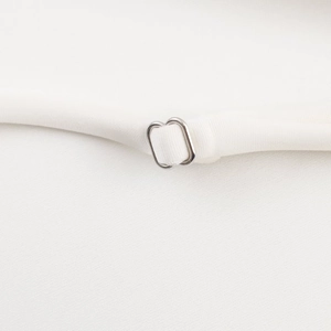 Gros plan sur la texture du tissu blanc avec boucle à anneau de réglage en métal argenté