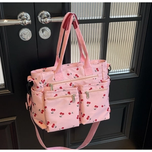 Close-up of pink nylon tote bag with cherry print and multi-pocket functional design