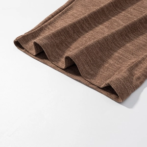 Makro-Detail des braunen Strickoberteil-Saums mit feiner Textur und glattem Abschlussrand