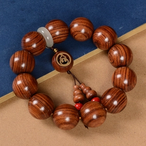 Bracelet bouddhiste en bois de poirier avec anneau de jade et gland sur tissu bleu