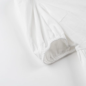 Détail rapproché du poignet bouffant blanc avec une conception élastique froncée