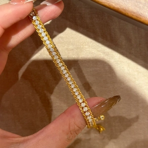 Vue macro détaillée du bracelet chaîne dorée avec des zircons blancs étincelants