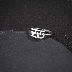 Macro shot of silver stainless steel adjustable ring with 555 hollow number design