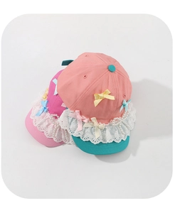 Detail view of pink kids baseball cap with white lace, colorful bows and pearl string