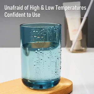 Minimalist translucent blue mouthwash cup on wooden tray with water droplets