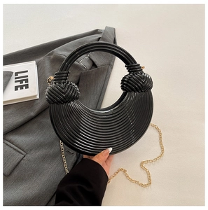 Détail du sac croissant noir avec texture plissée radiale et chaîne dorée fine