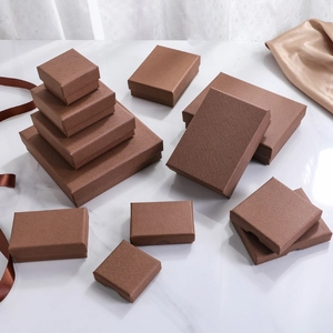 Textured brown jewelry boxes in various sizes for rings and necklaces on marble background