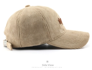 Detailed side view of khaki corduroy baseball cap with brown letter embroidery