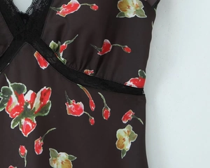 Detailaufnahme von floralem Satinstoff mit schwarzem Spitzenbesatz am Ausschnitt