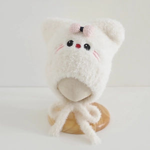 Close-up of soft plush cat ear hat with pink plaid bow and detailed animal embroidery
