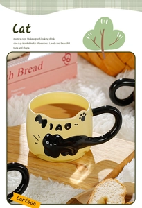 Detail of creative black cat tail handle and relief pattern on yellow ceramic mug