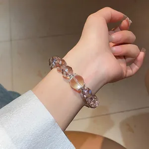Faceted brown crystal bead bracelet with silver floral spacers on a wrist