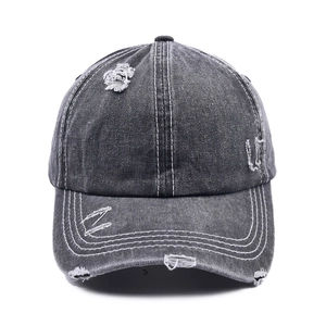 Close-up of distressed baseball cap with vintage frayed holes and white contrast stitching