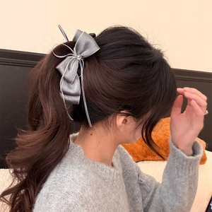 Elegant silver-grey chiffon bow hair clip with ribbons worn on a high ponytail style