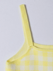 Detail of yellow and white plaid knitted tank top showing stitching and fabric texture