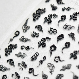 Macro shot of 5D embossed black Chinese cloud pattern nail art stickers with relief texture