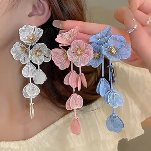 Floral tassel earrings with crystal center in white, pink and blue displayed on model