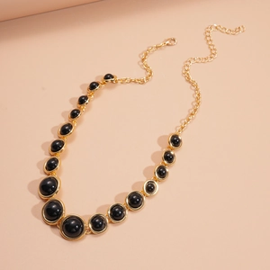 Detailed view of vintage gold chain necklace with black resin beads and lobster clasp
