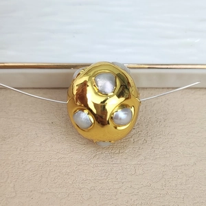 Detailed view of irregular natural freshwater pearls set in a gold-plated spacer bead