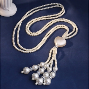 Detailed macro view of the elegant heart pendant with pearl tassels on a multi-layer necklace