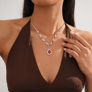 Detailed view of luxury Y-shaped silver-tone necklace with red teardrop pendant on model