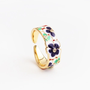 Detalle de anillo ajustable con flor de esmalte morado y centro de circón brillante