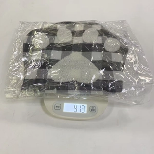 Detail of Christmas buffalo plaid paw stocking inside protective plastic packaging