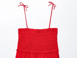 Detail of red cotton midi dress featuring tie-up straps and pleated ruched bodice texture