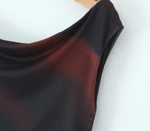 Dettaglio del tessuto mesh sfumato nero e rosso con focus su scollatura e cucitura spalla