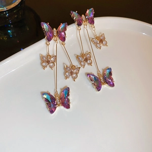 Detail of purple butterfly tassel earrings with gradient crystals and rhinestone accents