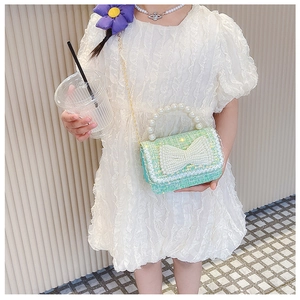 Détail du sac enfant en tweed vert menthe avec nœud en perles et chaîne dorée