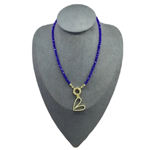Blue beaded necklace with crystal eyes and gold heart pendant on mannequin