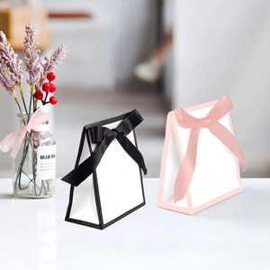 Minimalist black and pink ribbon bow gift bags in a trapezoidal paper handbag design