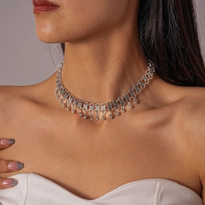 Close-up of vintage silver choker necklace with textured links and dangling small round beads