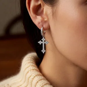 Silver cross pendant hoop earrings with zircon stones worn by a female model